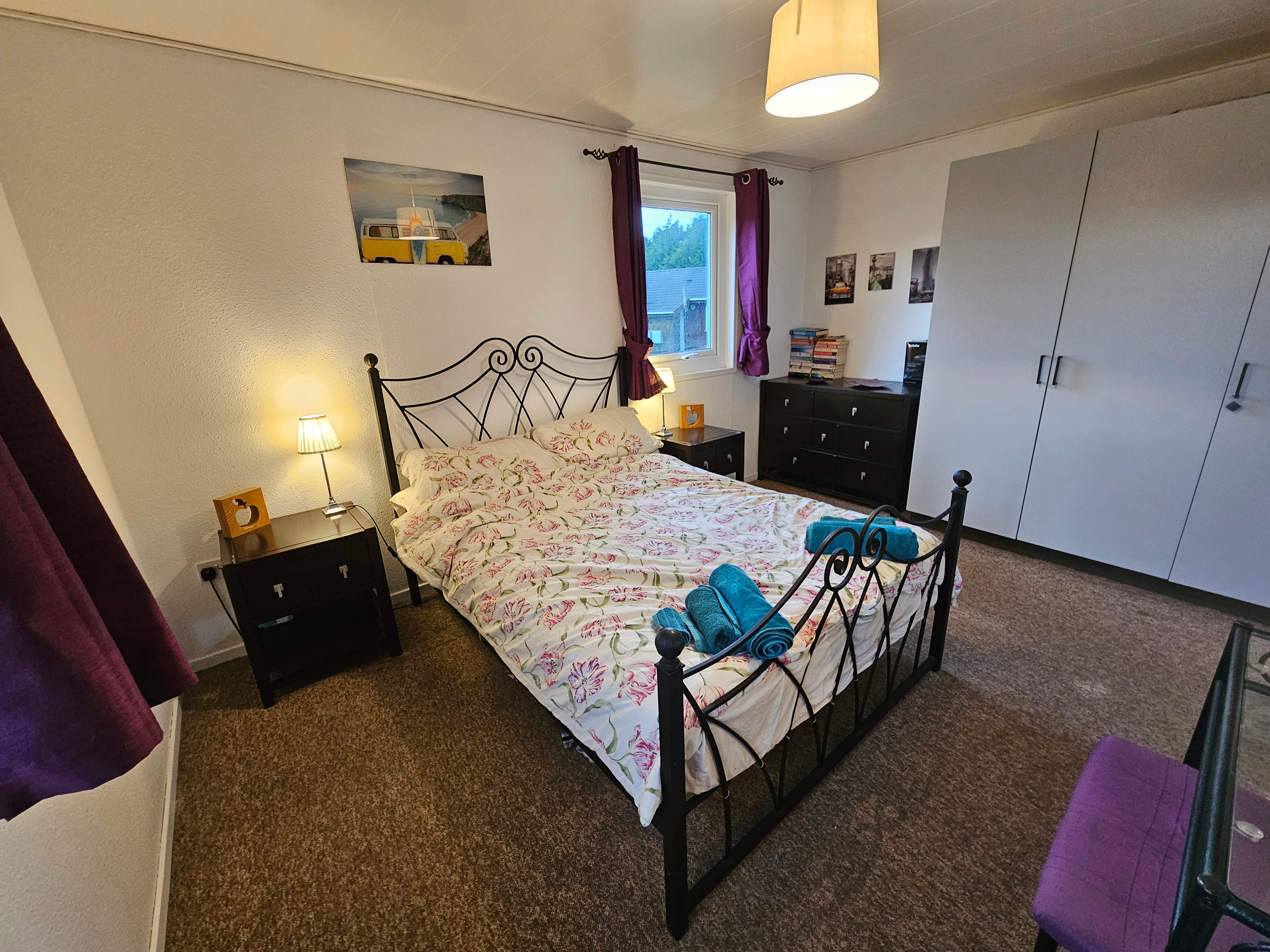 The main bedroom which has a double bed, vanity, dresser and wardrobe